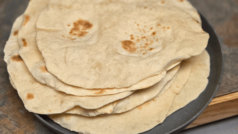Homemade sourdough tortillas piled on a plate