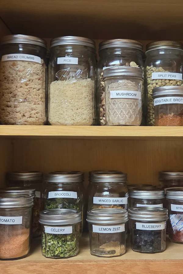 a well stocked pantry with mason jars full of homemade mixes, dehydrated foods and more.